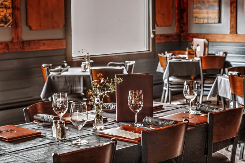 Timber-lined dining room with tables set for dinner, showing the family-run room