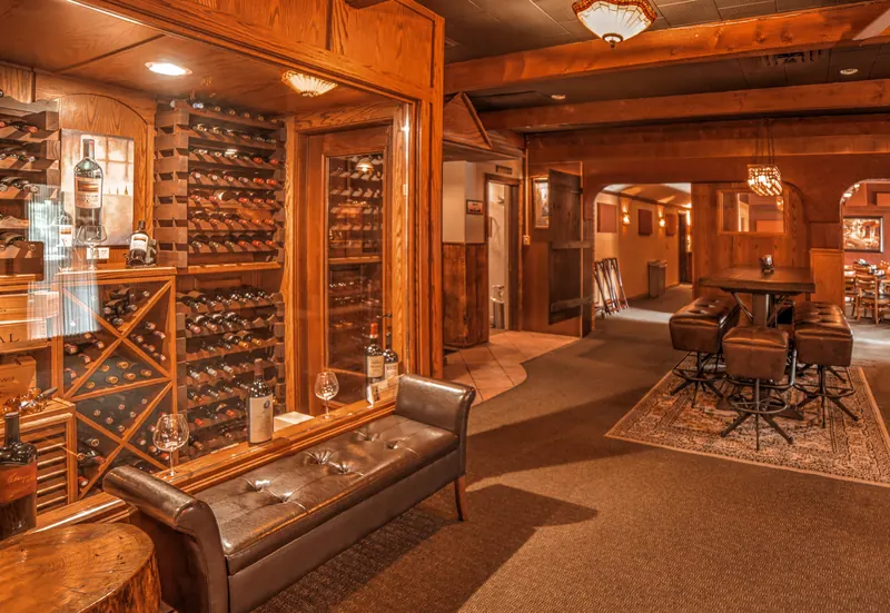 Wine racks and leather seating beside the cellar, opening into Bennethum’s wood-paneled lounge