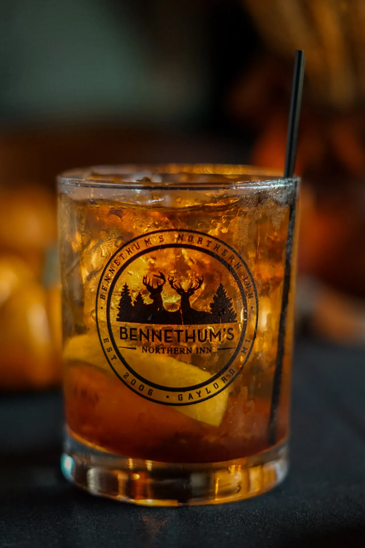 Amber drink over ice in a Bennethum's branded glass